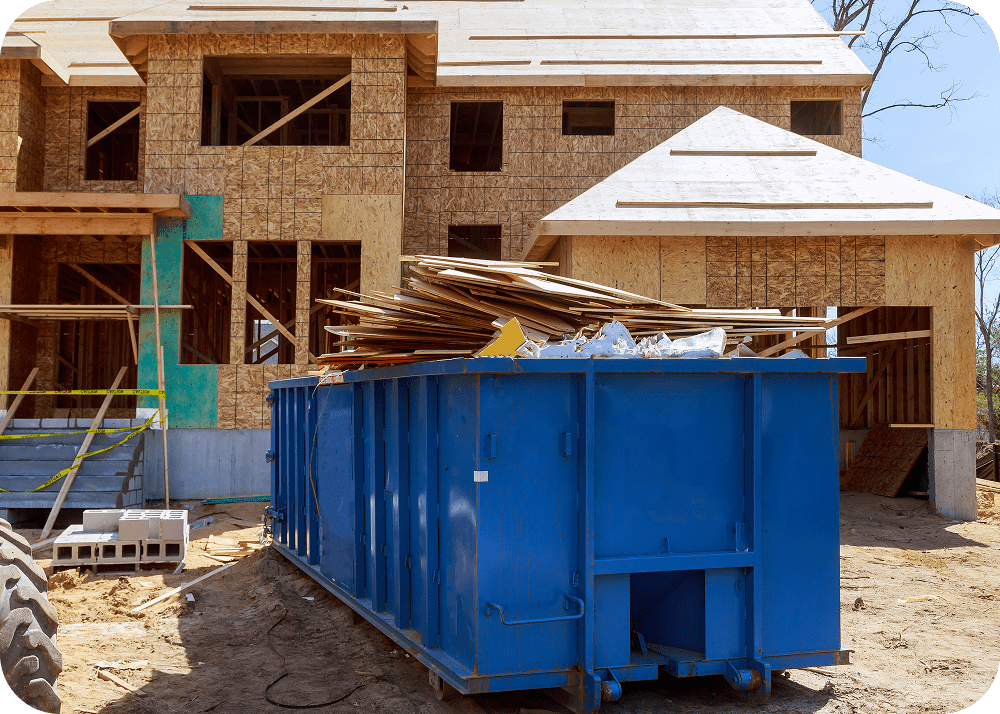 Blue dumpster filled with debris at construction site